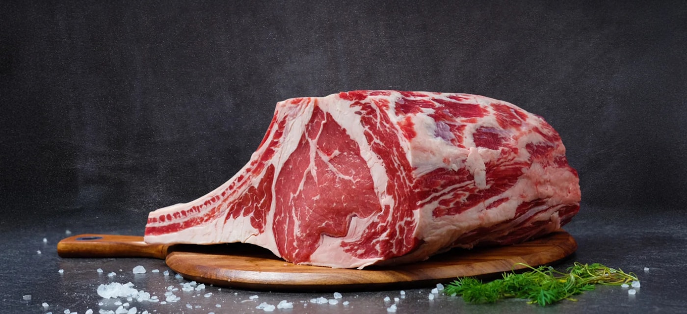 Large prime rib cut on a wooden board