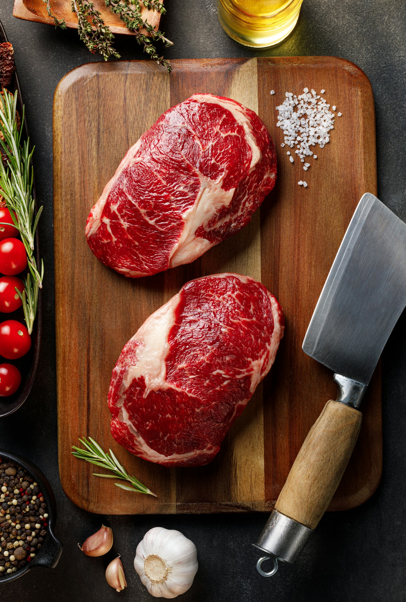 Two fresh ribeye steaks on a board